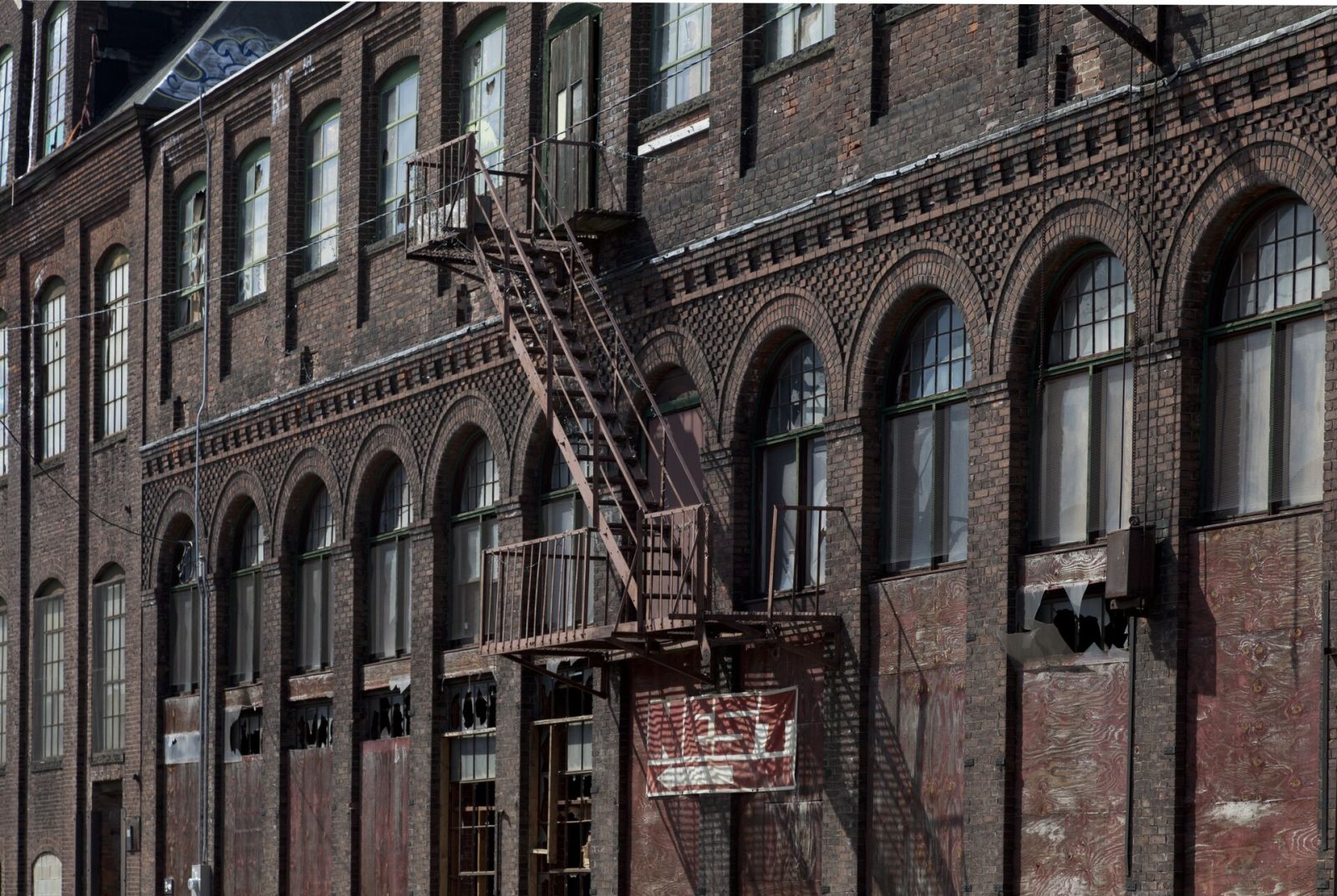 Older brick building with fire escapes, awaiting repositioning